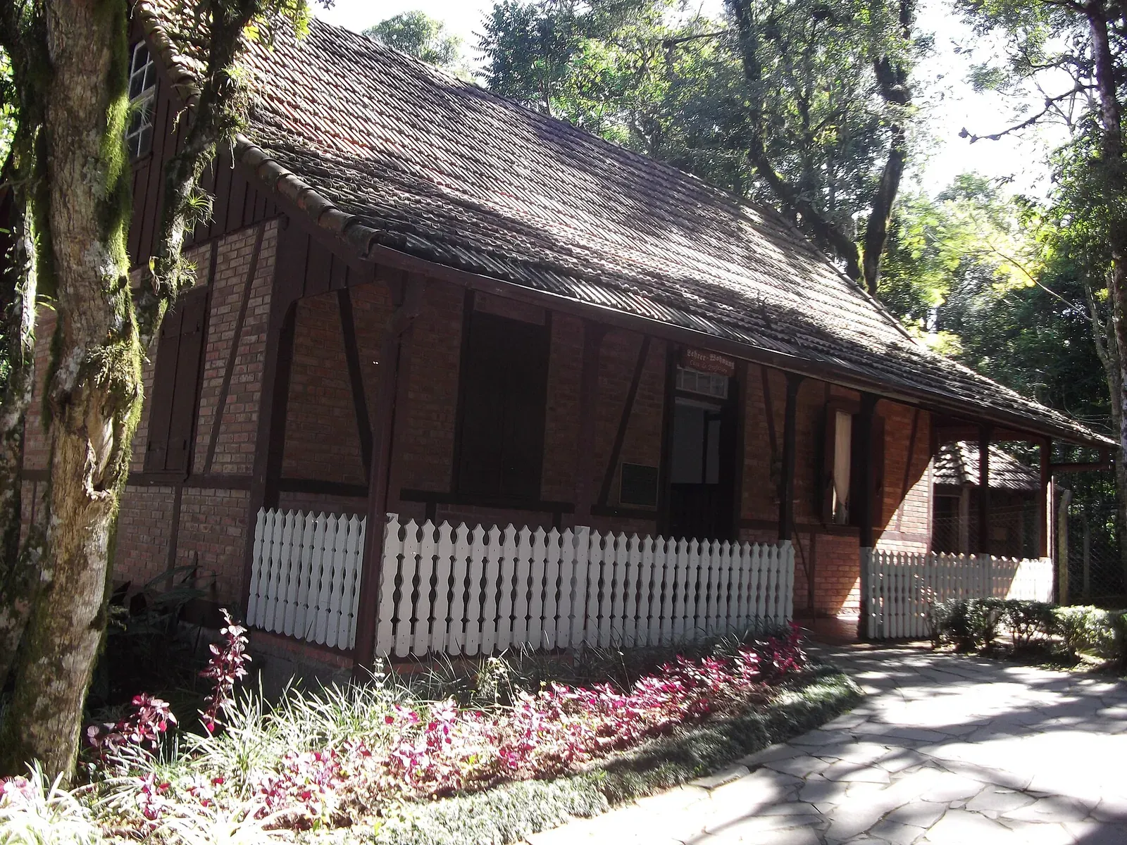 Casa em enxaimel com cerca branca e jardim no Parque Aldeia do Imigrante