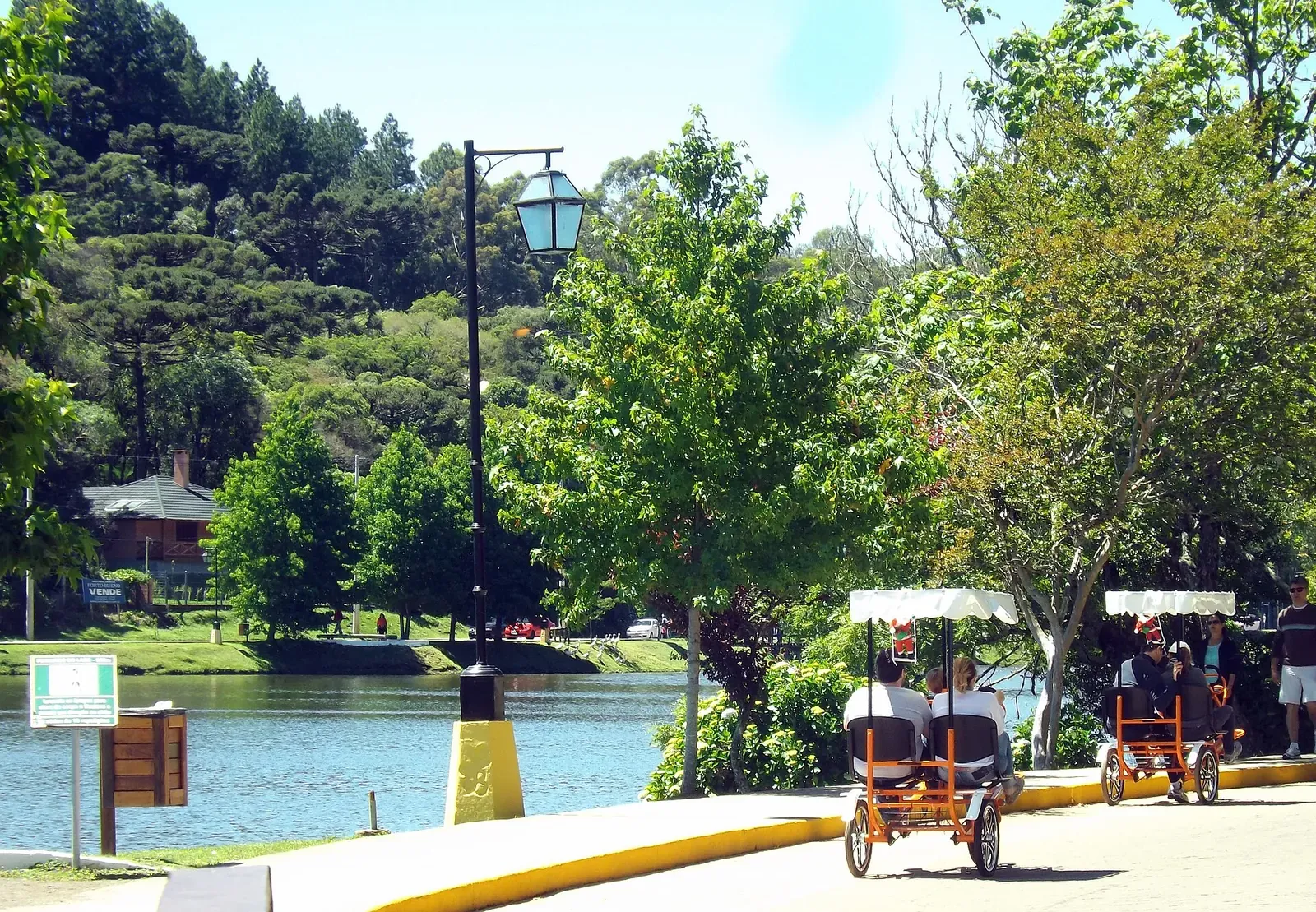 Orla do Lago São Bernardo com triciclos de aluguel e postes de ferro