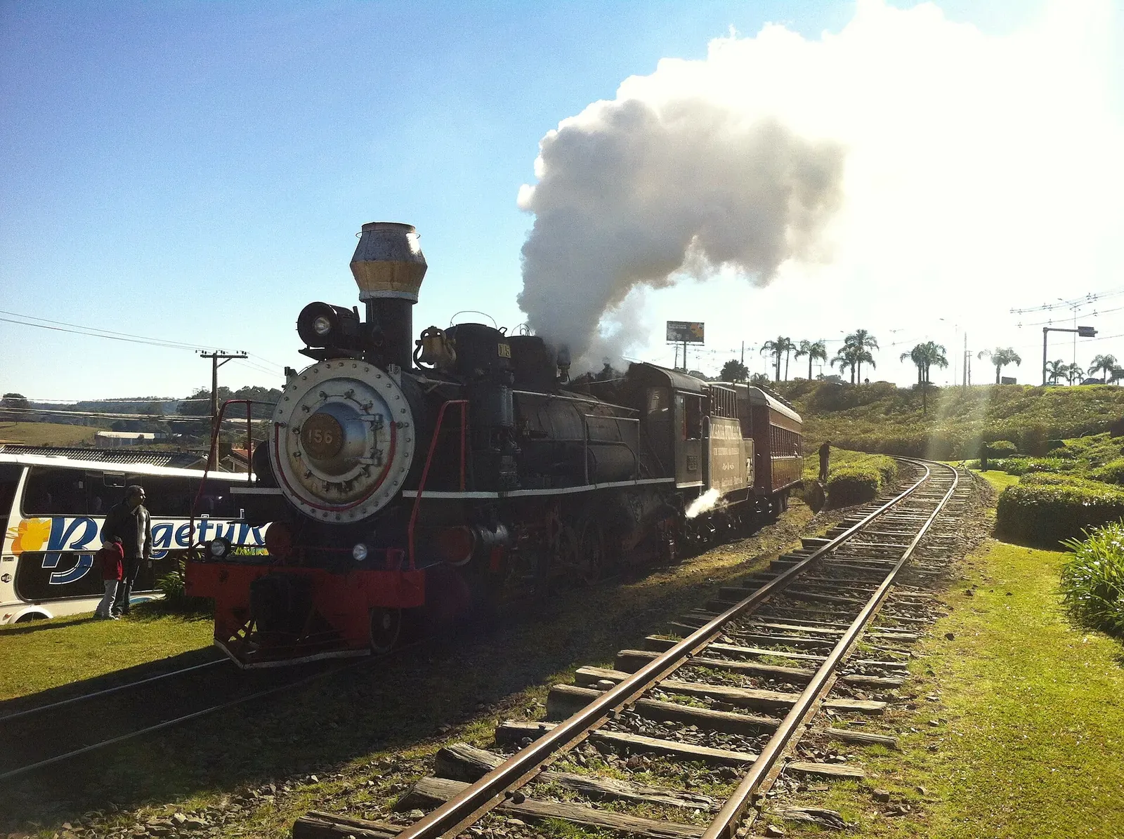 Locomotiva a vapor da Maria Fumaça soltando fumaça sobre os trilhos