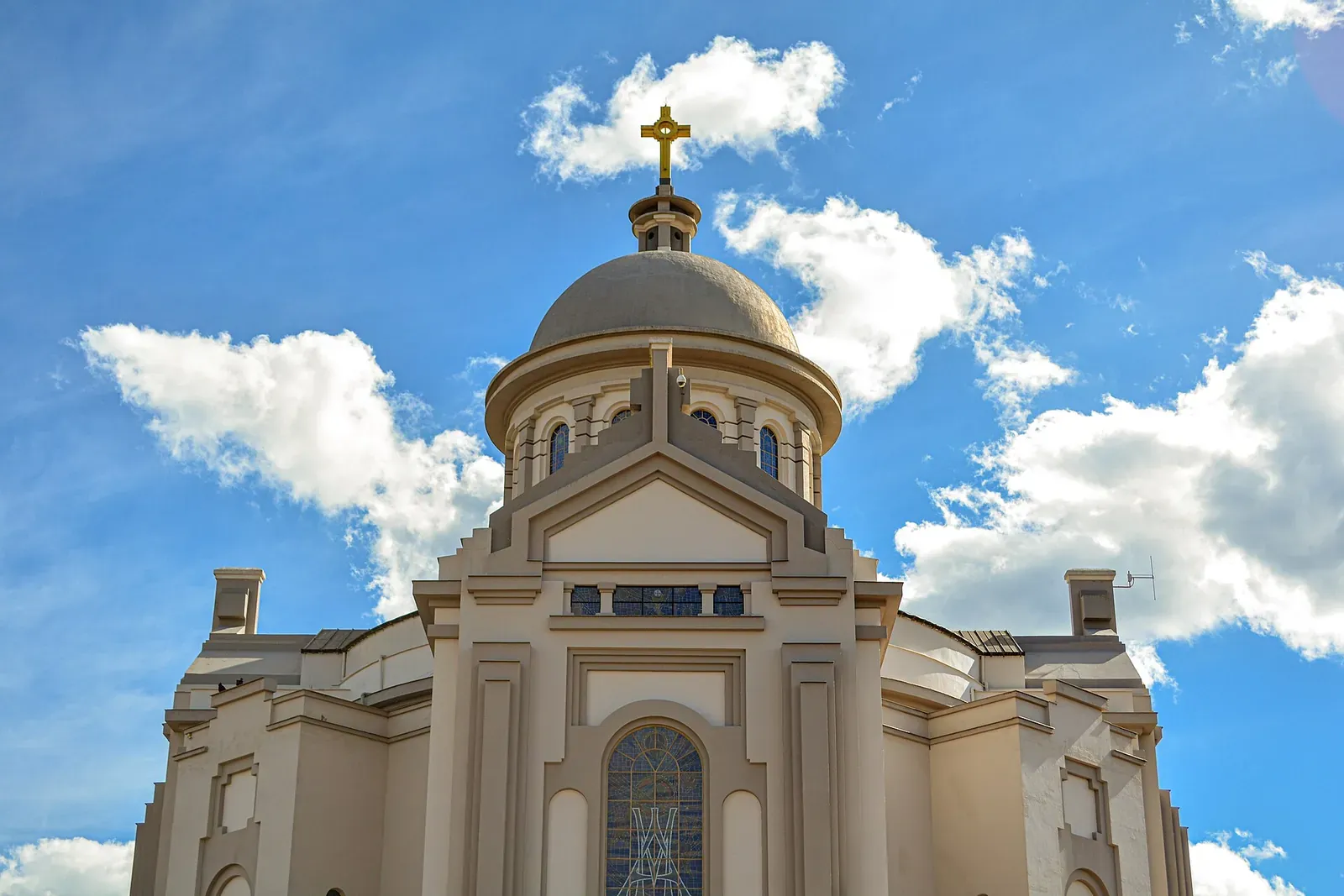 Cúpula e fachada do Santuário de Nossa Senhora de Caravaggio sob céu azul